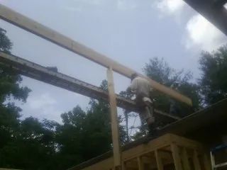 Carpenter setting a ridge beam over a new addition frame — Ice Dam Removal by Roofing Brothers in East Greenwich