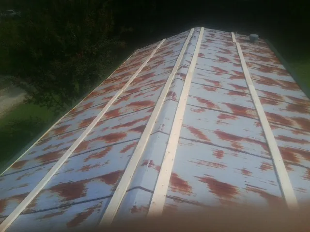 Rusted metal roof panels with new wood purlins before replacement — Storm Damage Roof Repair in East Greenwich by Roofing Brothers