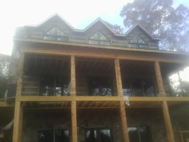 Dormers and porch framing on a large log home under construction — Roof Coating work by our crew in East Greenwich