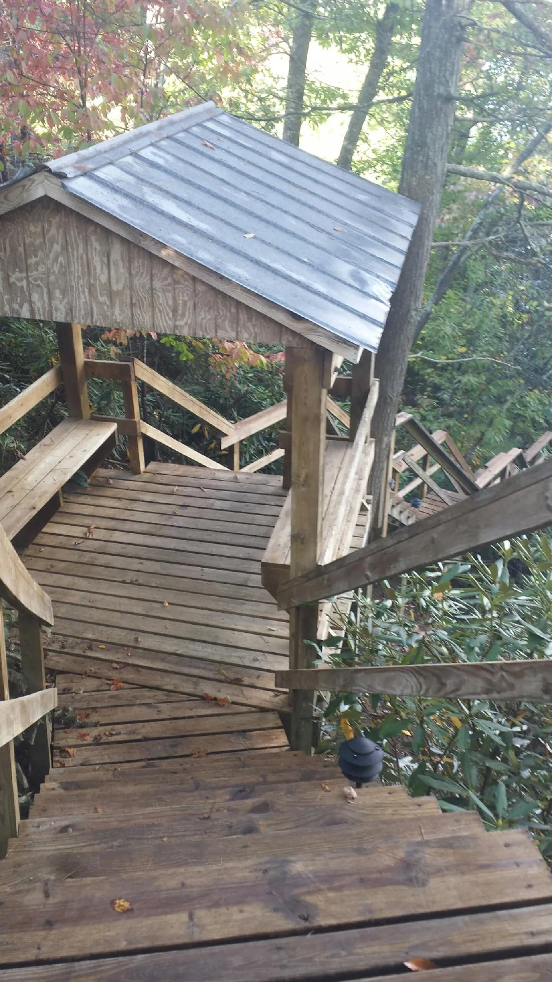 Metal roofed shelter over wooden steps on a wooded walkway — Skylight Repair & Installation work by our crew in East Greenwich